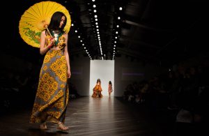 A model who benefits from online therapy confidently walking in a catwalk during the fashion show 